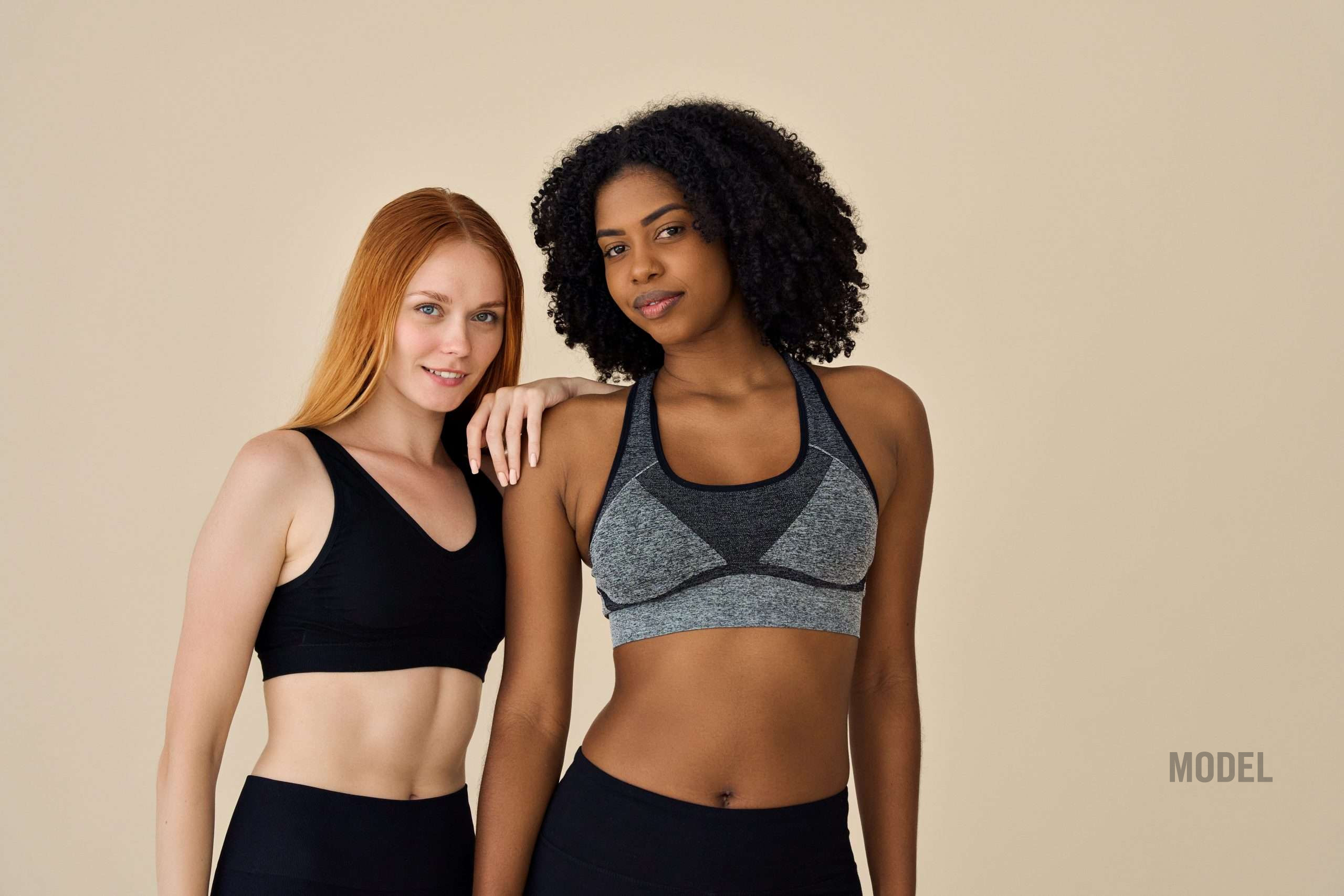 Two women in athletic wear representing natural breast augmentation for active patients